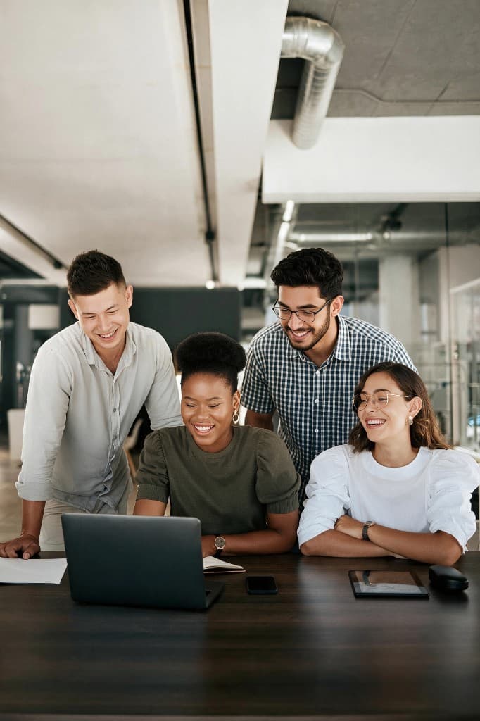 Career professionals collaborating around a laptop in a modern workspace